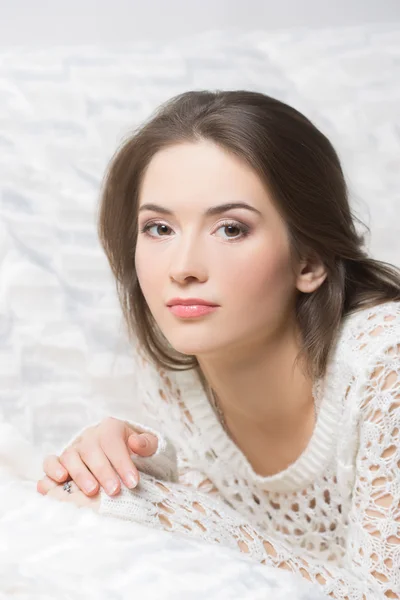 Smiling girl sitting on sofa — Stock Photo, Image