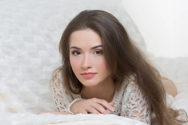 Chica sonriente sentada en el sofá — Foto de Stock