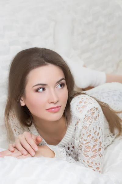 Chica sonriente sentada en el sofá — Foto de Stock