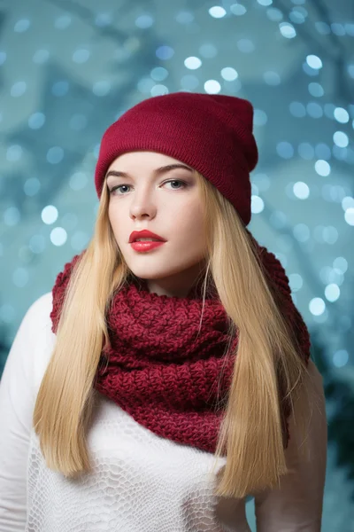 Menina bonita em um chapéu vermelho em uma grinalda de Natal — Fotografia de Stock