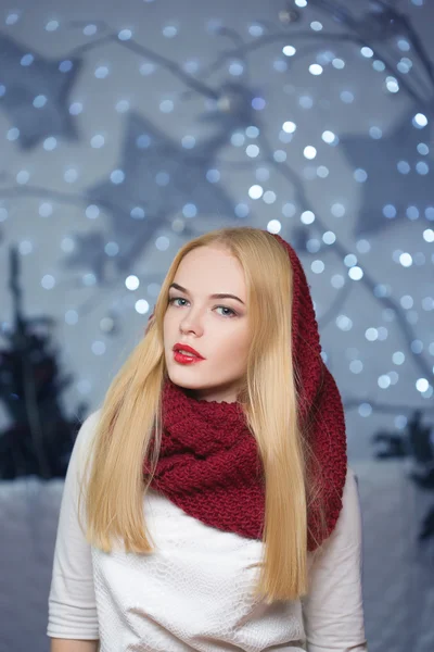Beautiful girl in a red hat at a Christmas garland — Stock Photo, Image