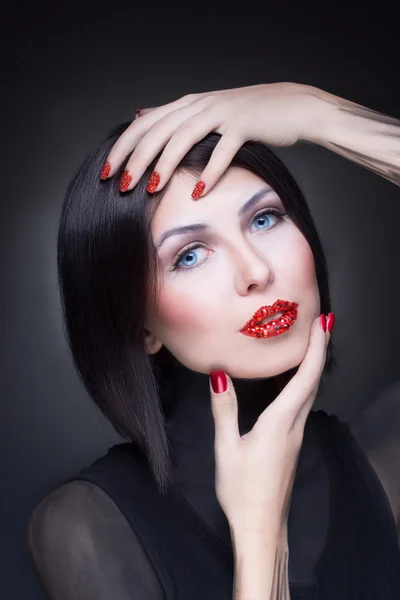 Mujer con pedrería en sus labios y uñas — Foto de Stock