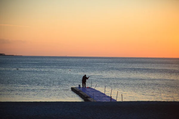 Silhouette assise jeune femme au coucher du soleil — Photo