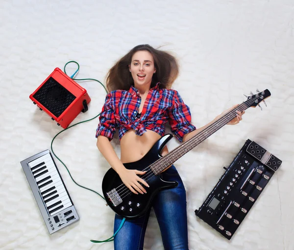 Menina deitada no chão com guitarra baixo — Fotografia de Stock