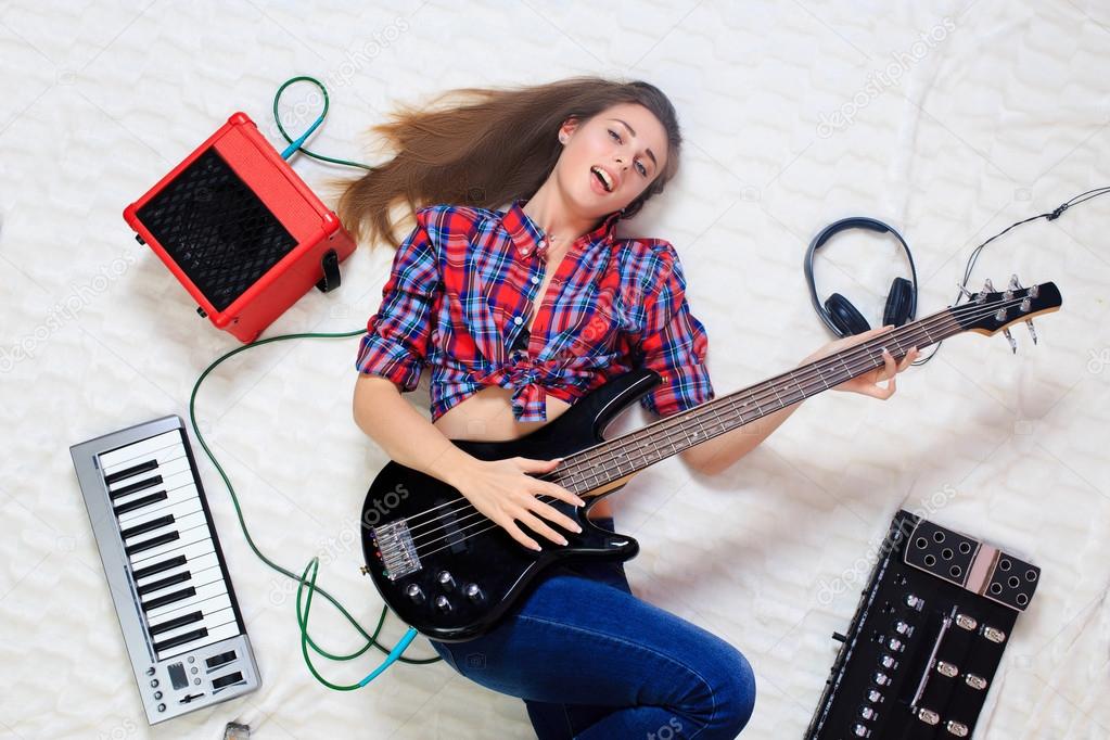 girl lying on the floor with bass guitar