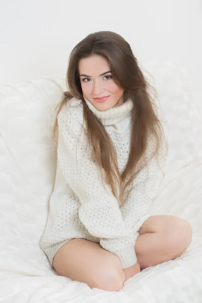 Smiling girl sitting on sofa — Stock Photo, Image