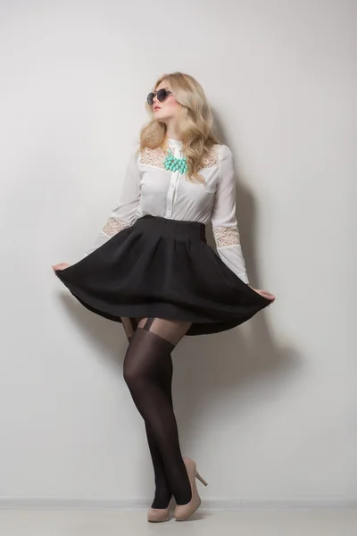 Blonde with long hair in a skirt. black sunglasses — Stock Photo, Image