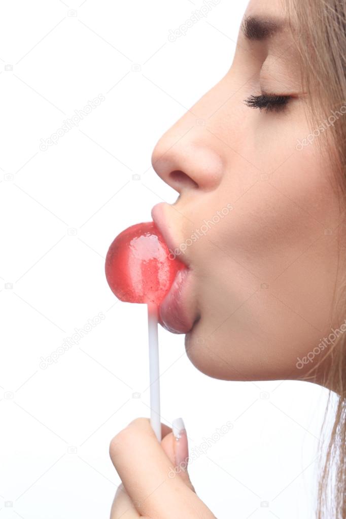 closeup girl sucks a lollipop.