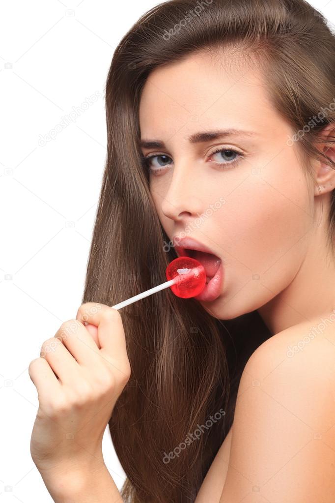 girl with beautiful hair sucks a lollipop.