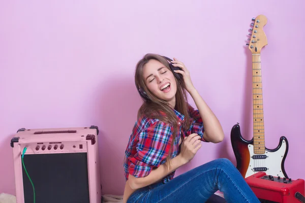 Chica en auriculares escucha música. eléctrico . — Foto de Stock