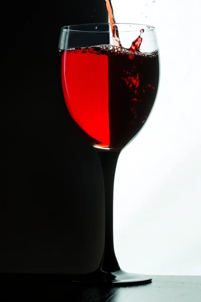 Red wine pouring. white on black background — Stock Photo, Image