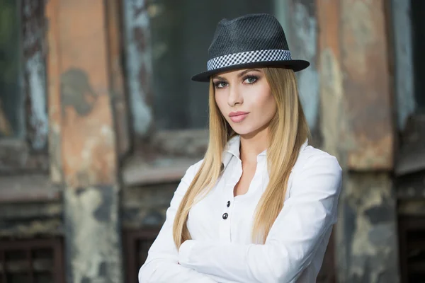 Beautiful blonde in a white blouse and a hat — Stock Photo, Image