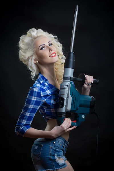 Blonde with industrial hammer. dark background. — Stock Photo, Image