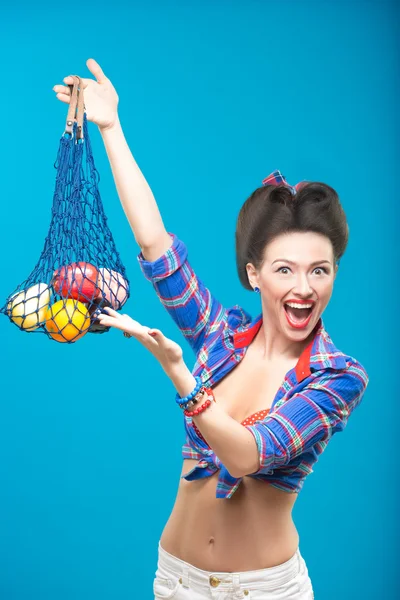 Женщина с пинап макияжем с мешком фруктов — стоковое фото