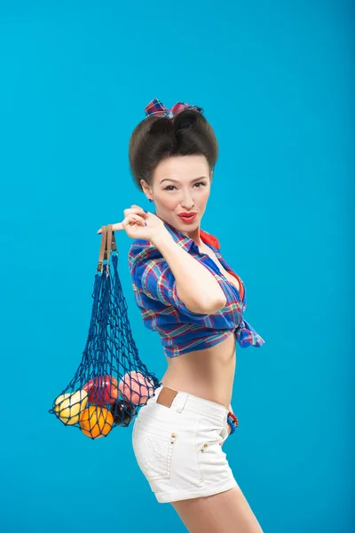 Mulher com pin-up maquiagem com um saco de frutas — Fotografia de Stock