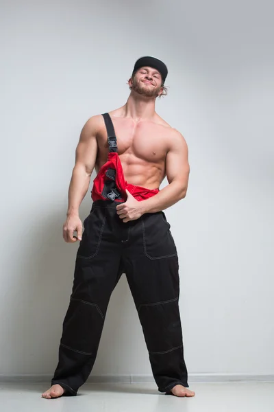 Muscular construction worker in overalls — Stock Photo, Image