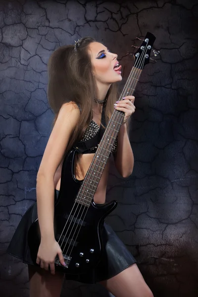 Woman playing music on a bass guitar — Stock Photo, Image