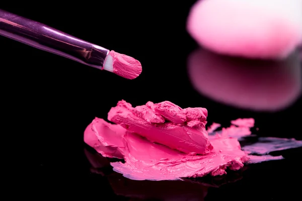 Lippenstift mit Pinsel-Make-up auf schwarz — Stockfoto