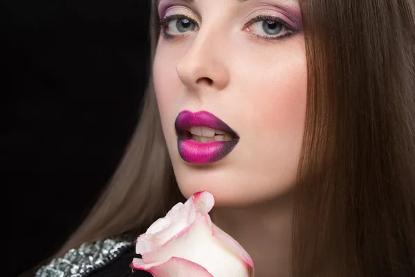Cara de mujer con labios lila y flor rosa . — Foto de Stock