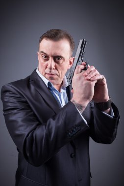 elinde silah olan iş elbiseli adam