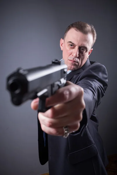 Мужчина в деловом костюме с пистолетом — стоковое фото