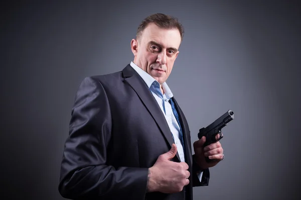 Un hombre con un traje de negocios con un arma — Foto de Stock