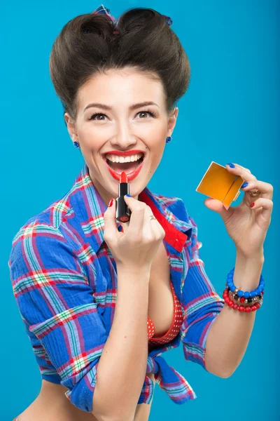 Sexy young pin-up girl doing make-up — Stock Photo, Image