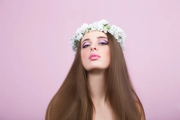 Modelo jovem com flores brilhantes na cabeça — Fotografia de Stock