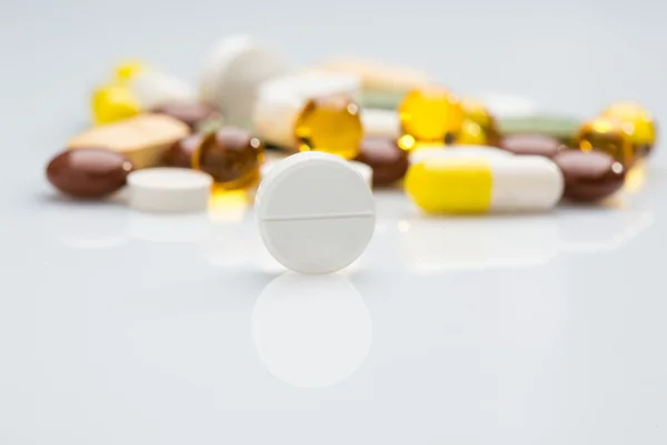 Stos różnych tabletek kolorowy na białym tle — Zdjęcie stockowe