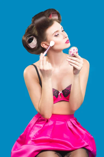 Kvinna i papiljotter ansöker rouge. makeup borste. — Stockfoto