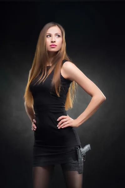 Девушка в черном платье с пистолетом — стоковое фото