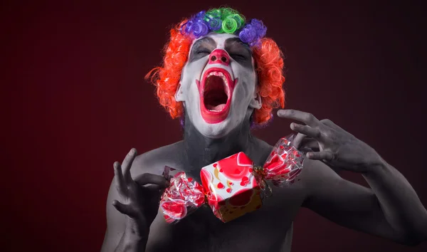 Payaso aterrador con maquillaje espeluznante y más dulces — Foto de Stock