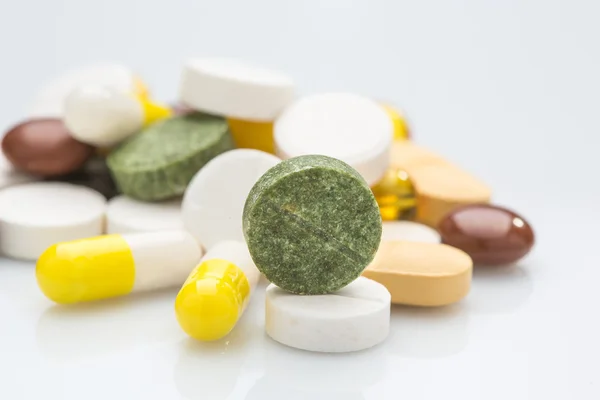Stapel van verschillende kleurrijke pillen geïsoleerd op wit — Stockfoto