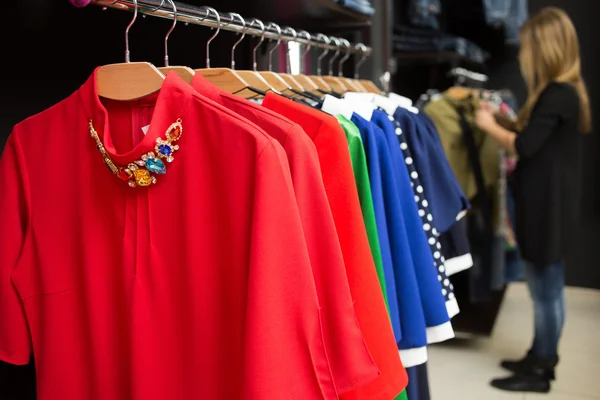 Vestidos de mujer en perchas en una tienda al por menor — Foto de Stock