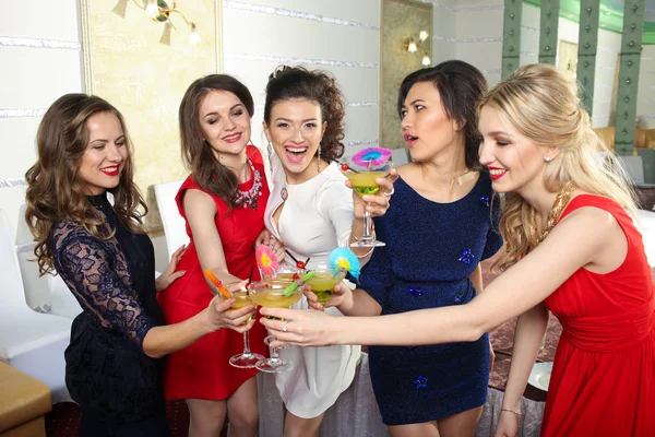 Girls clinking glasses of cocktails at the party — Stock Photo, Image