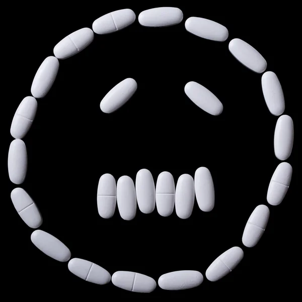 Bílé pilulky na černém — Stock fotografie