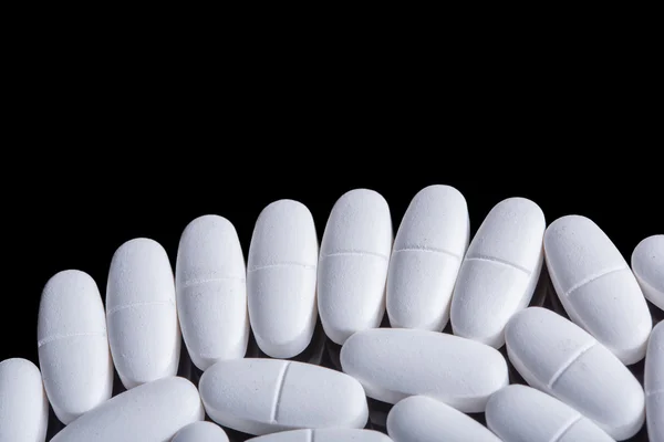 White pills on the black — Stock Photo, Image