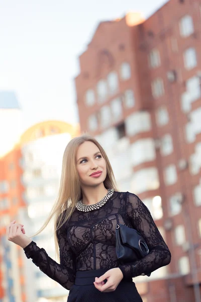 Fille debout sur le fond du bâtiment et tient les clés . — Photo