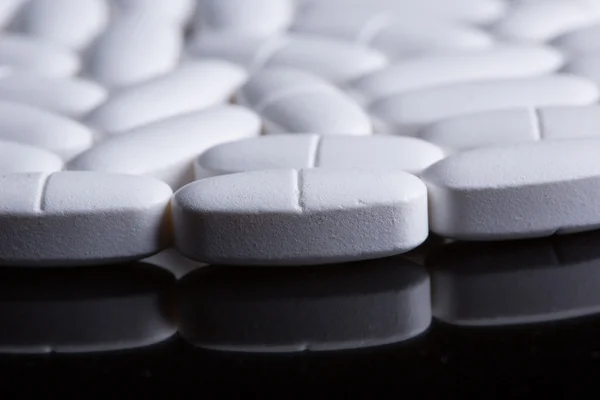 Białe tabletki na czarny — Zdjęcie stockowe