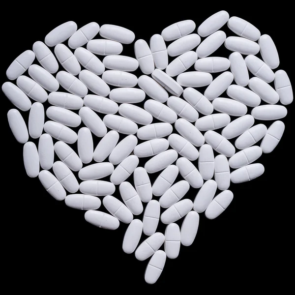 Heart of white oblong tablets — Stock Photo, Image