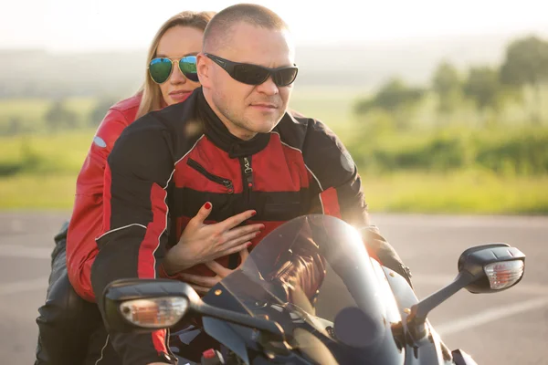 Motorkář muž a žena, sedící na motorce. — Stock fotografie