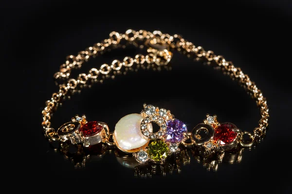 Golden bracelet with precious stones on black background — Stock Photo, Image
