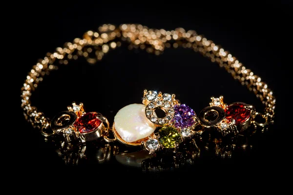 Golden bracelet with precious stones on black background — Stock Photo, Image