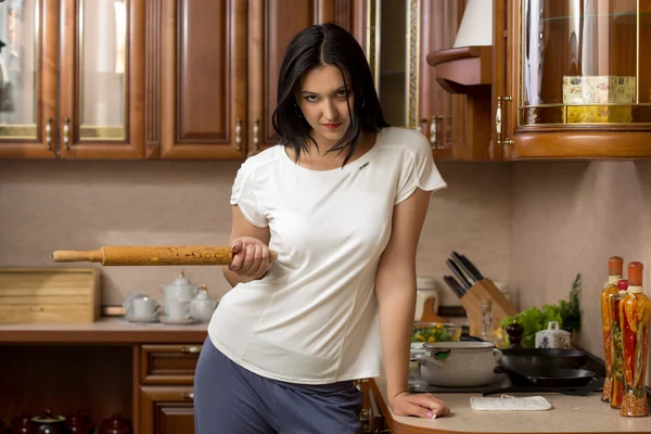 Housewife holding a rolling pin. It stands in the kitchen — Stock Photo, Image