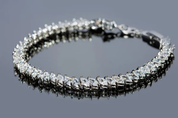 Stříbrný náramek s diamanty na šedém pozadí. — Stock fotografie