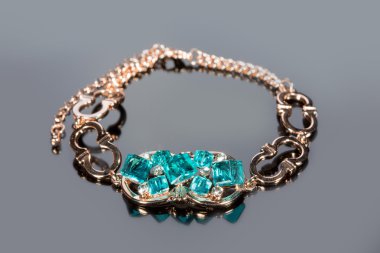 gri zemin üzerine altın bilezik. 