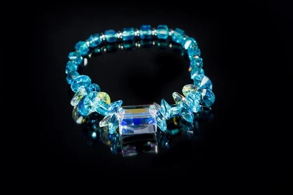 Beautiful blue plastic bracelet on black background. — Stock Photo, Image