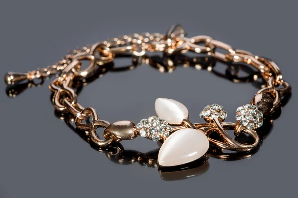 Bracciale in oro su sfondo grigio . — Foto Stock