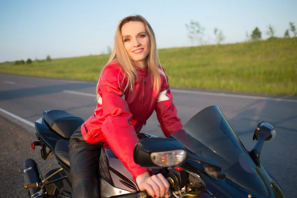 Mujer motorista sentada en una motocicleta . — Foto de Stock