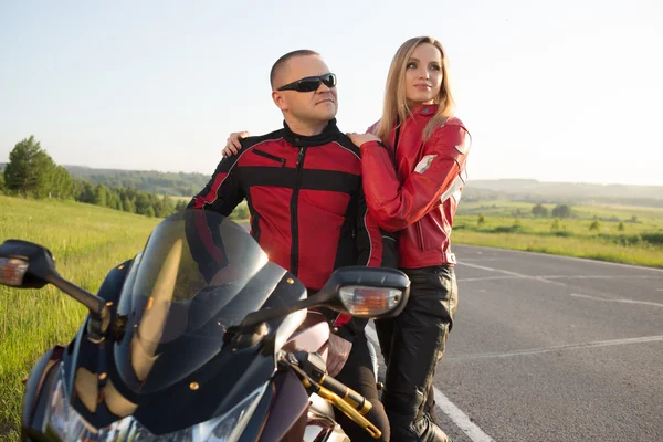 骑自行车的人男人和女人坐在一辆摩托车. — 图库照片